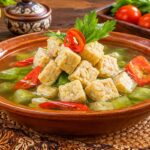 Bowl of clear tempeh soup with rice